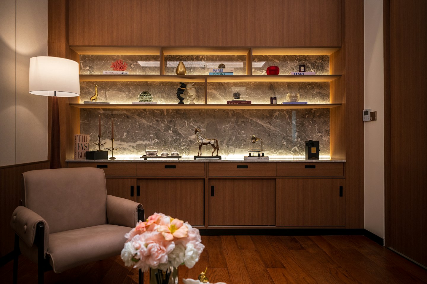 An armchair and bookshelf in a decorated living room.